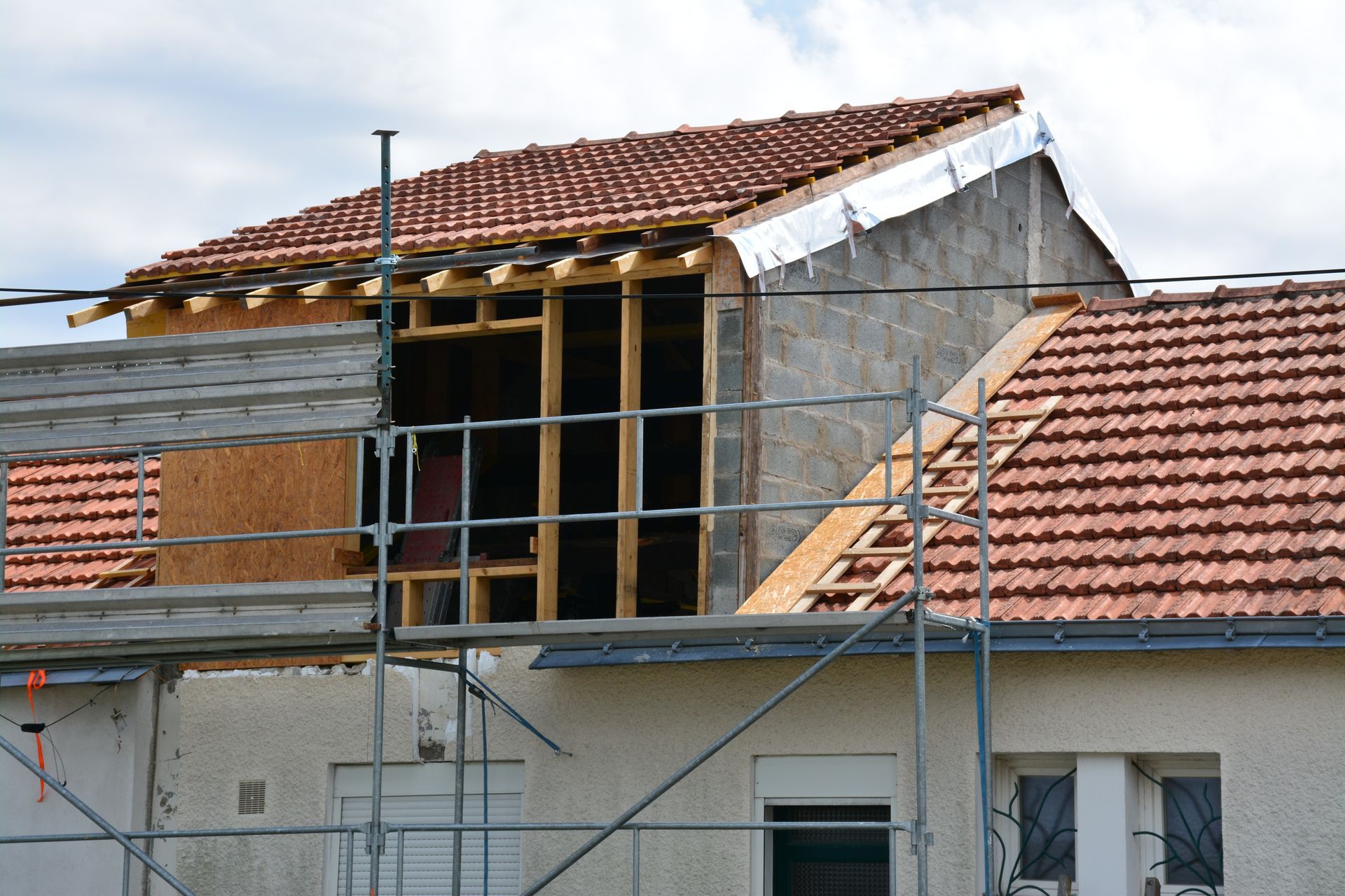Des travaux de surélévation sur une maison avec présence d'un échafaudage.