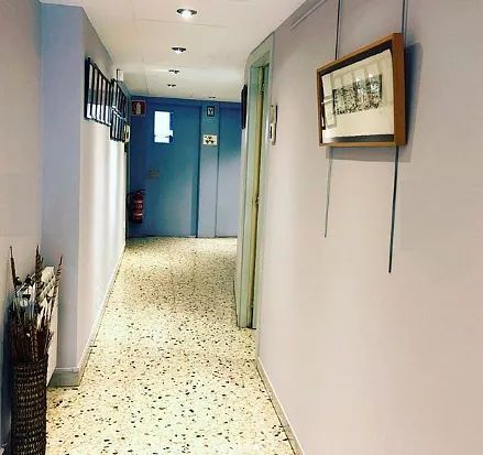 Un largo pasillo con un cuadro en la pared.