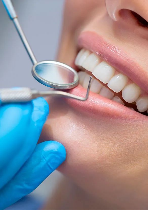 Una mujer está siendo examinada por un dentista.