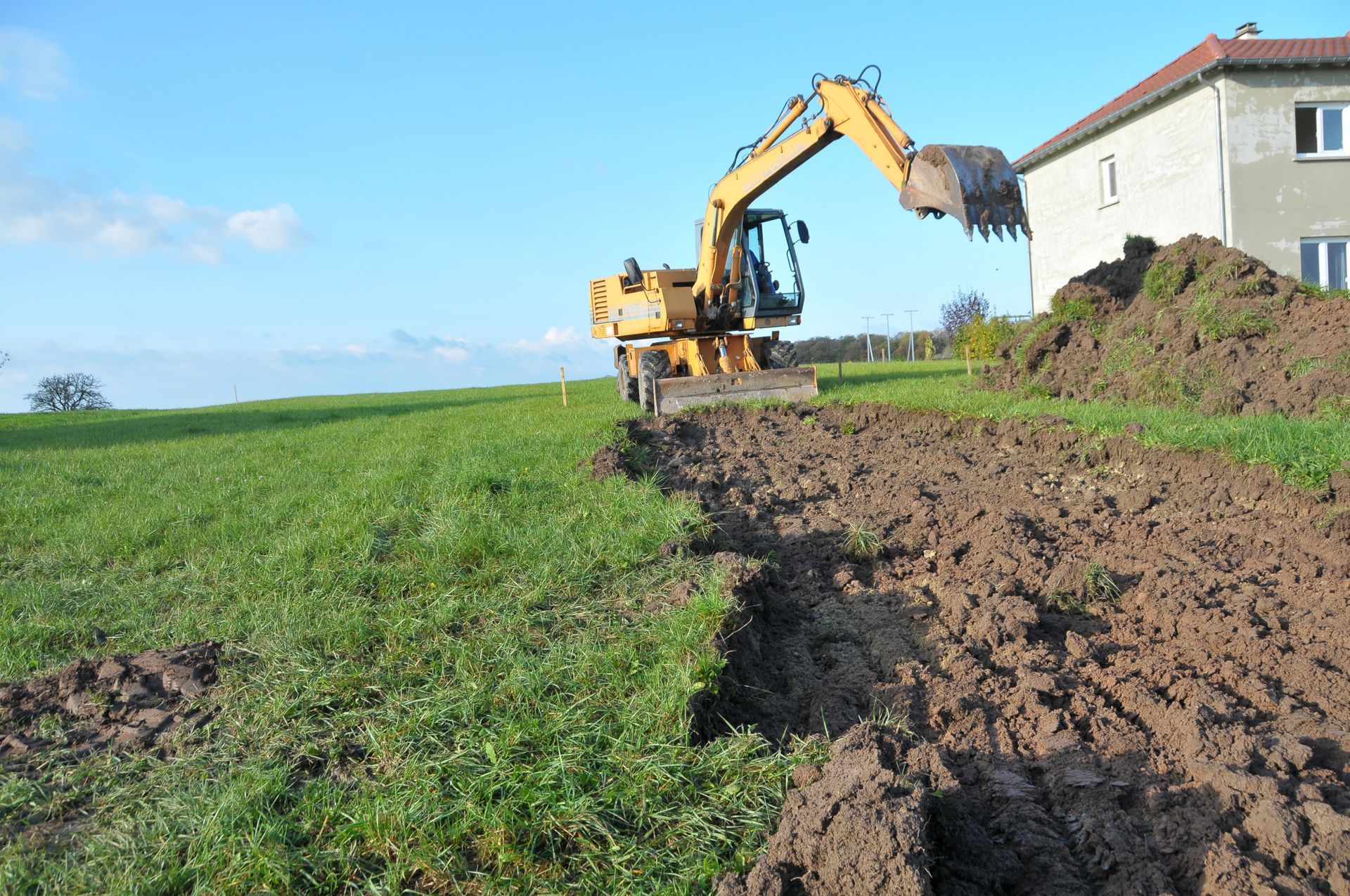 Gros plan sur une étroite tranchée creusée dans la terre brune, probablement pour des plantations.