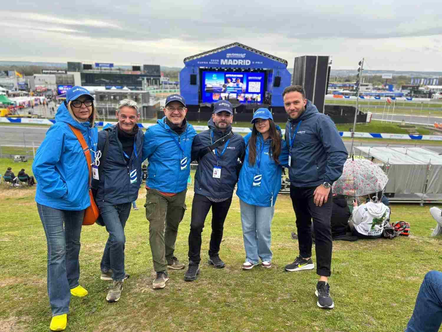 Cinco personas con chaquetas azules posan