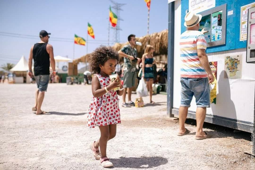 Máquina ionizadora de agua negra con dos botellas azules en bandejas circulares.