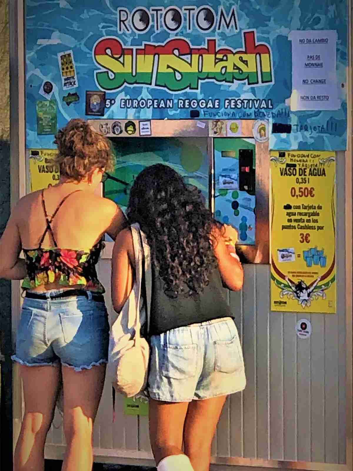 Dos personas leyendo el menú en la ventana de un colorido puesto de comida.