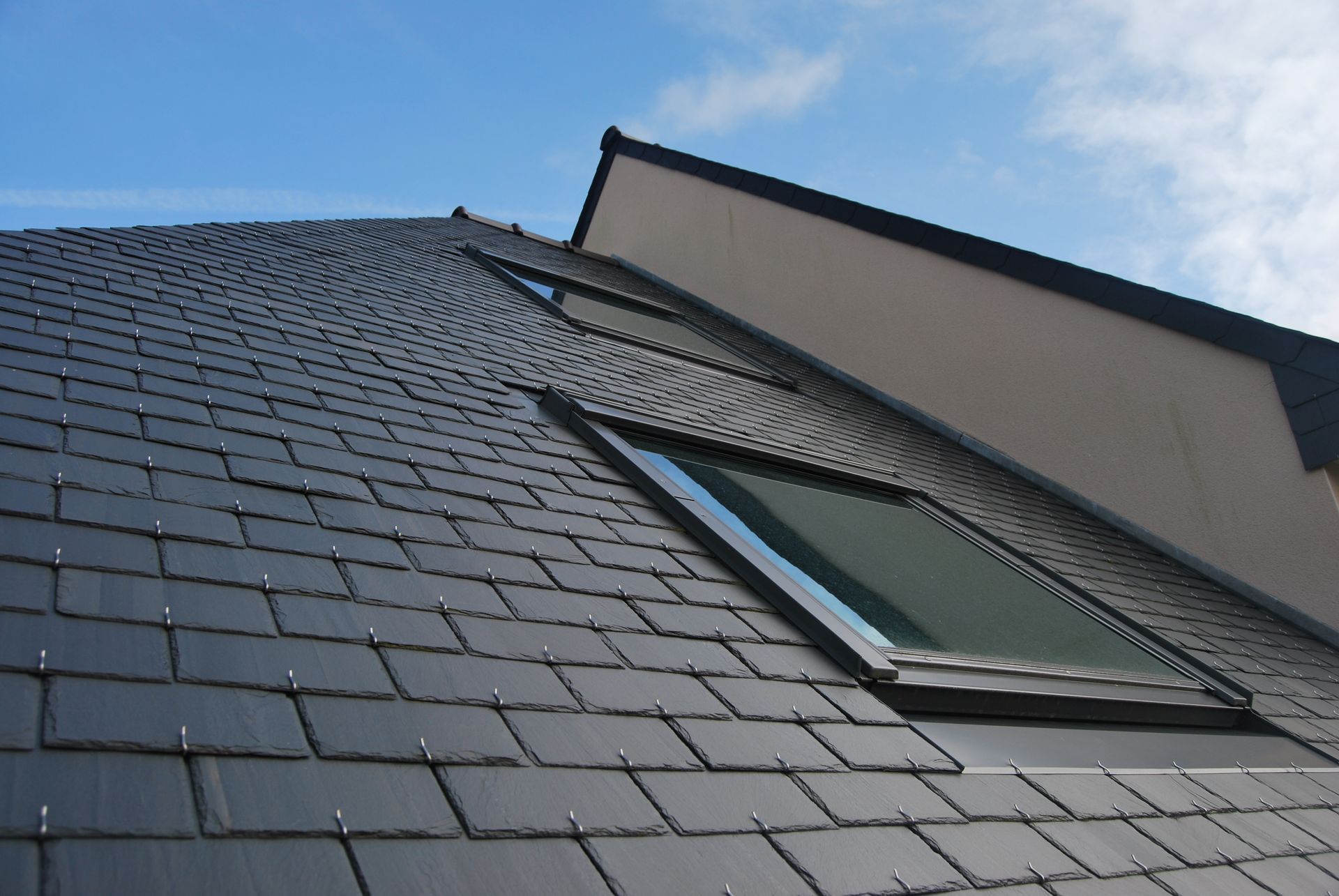 Toiture en ardoises avec fenêtre de toit intégrée de couleur noire