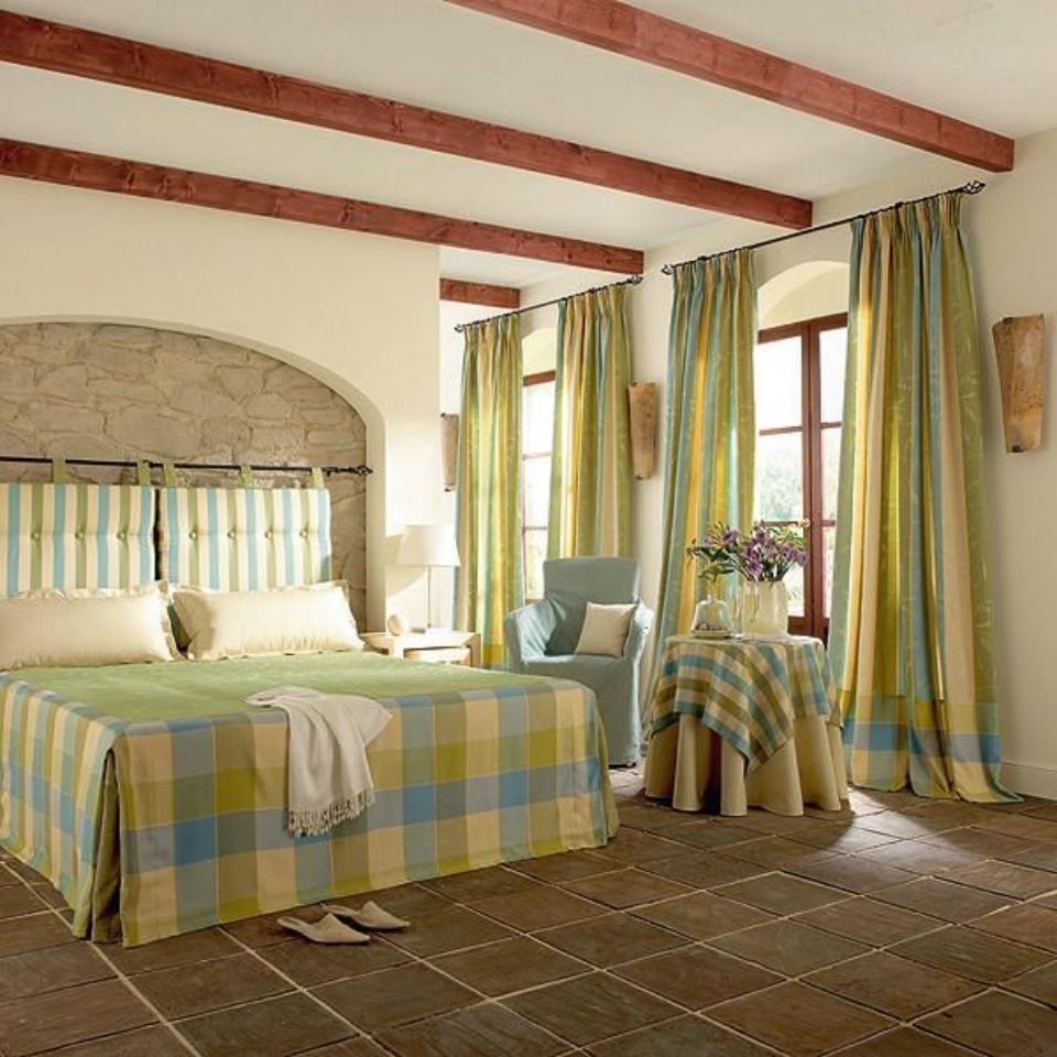 Esszimmer mit Tisch und Stühlen und gestreiften und gemusterten Gardinen