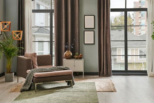 geschmackvoll eingerichteter Wohnbereich mit hellen Wänden, Couch, Sesseln, TV-Bereich und Essecke