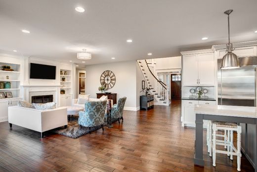 geschmackvoll eingerichteter Wohnbereich mit hellen Wänden, Couch, Sesseln, TV-Bereich und Essecke