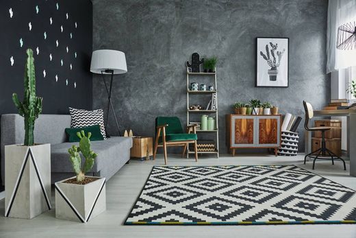 geschmackvoll eingerichteter Wohnbereich mit hellen Wänden, Couch, Sesseln, TV-Bereich und Essecke