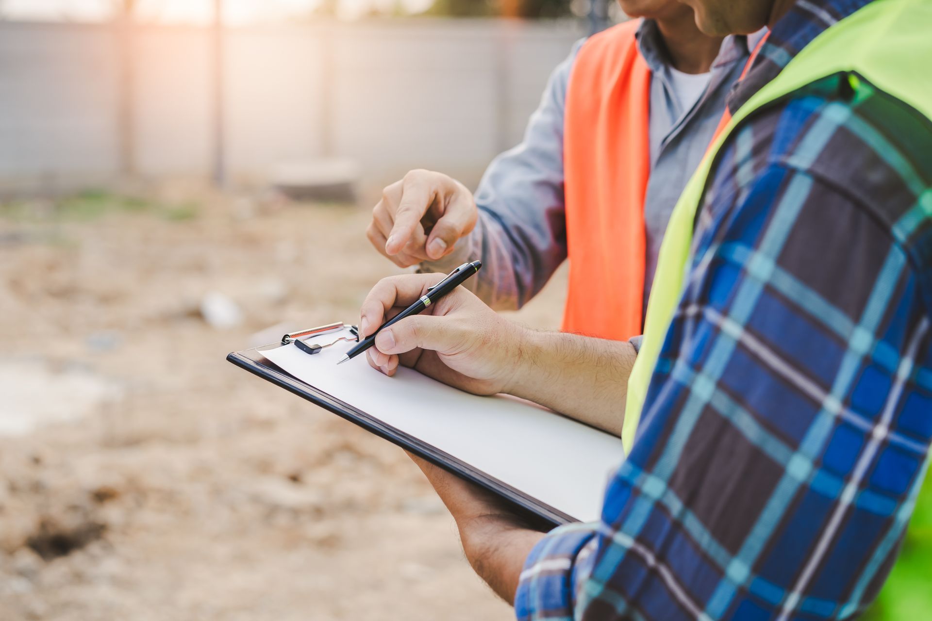 Deux ouvriers examinent des plans sur un chantier.