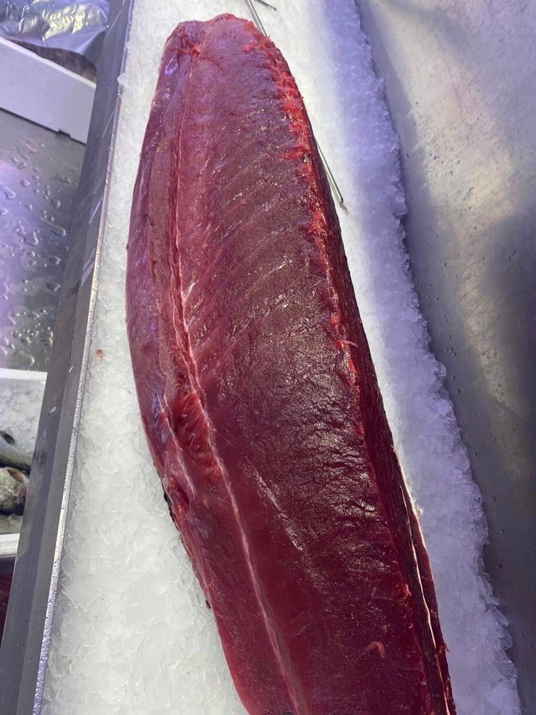 Un gran trozo de carne roja reposa sobre hielo.