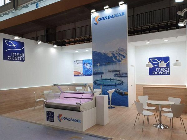 Un stand en el océano Mediterráneo con mesas y sillas.