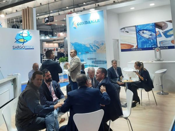 Un grupo de personas están sentadas alrededor de una mesa en una convención.