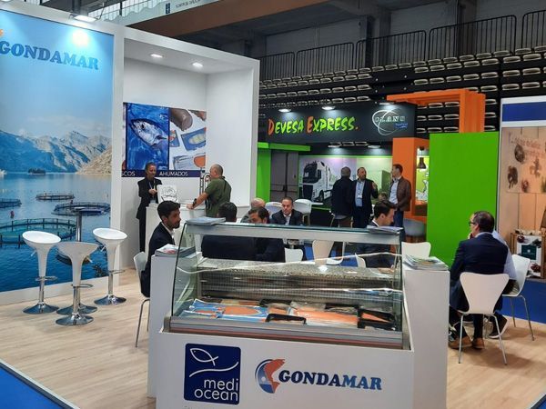 Un grupo de personas de pie alrededor de un stand que tiene escrito 