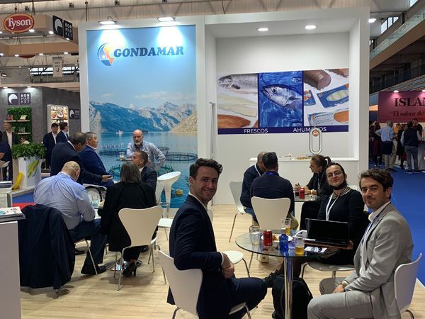 Un grupo de personas están sentadas en mesas en una convención.