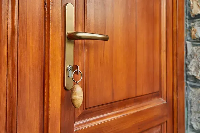 Un primer plano de una puerta de madera con una llave dentro.