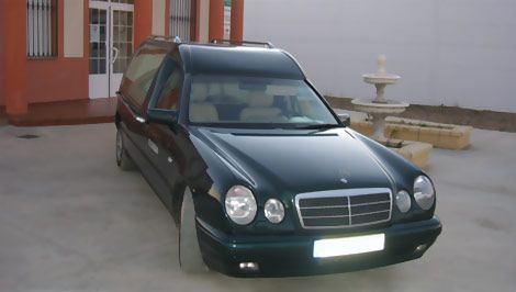 Un coche verde está aparcado delante de un edificio.