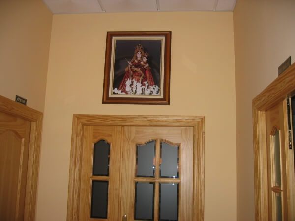 Una imagen de una mujer sosteniendo a un niño cuelga sobre una puerta.