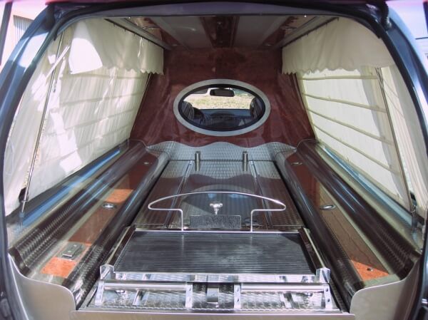 El interior de un vehículo funerario con un ataúd dentro.