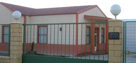 Una casa con una cerca y un cartel que dice 'atención'