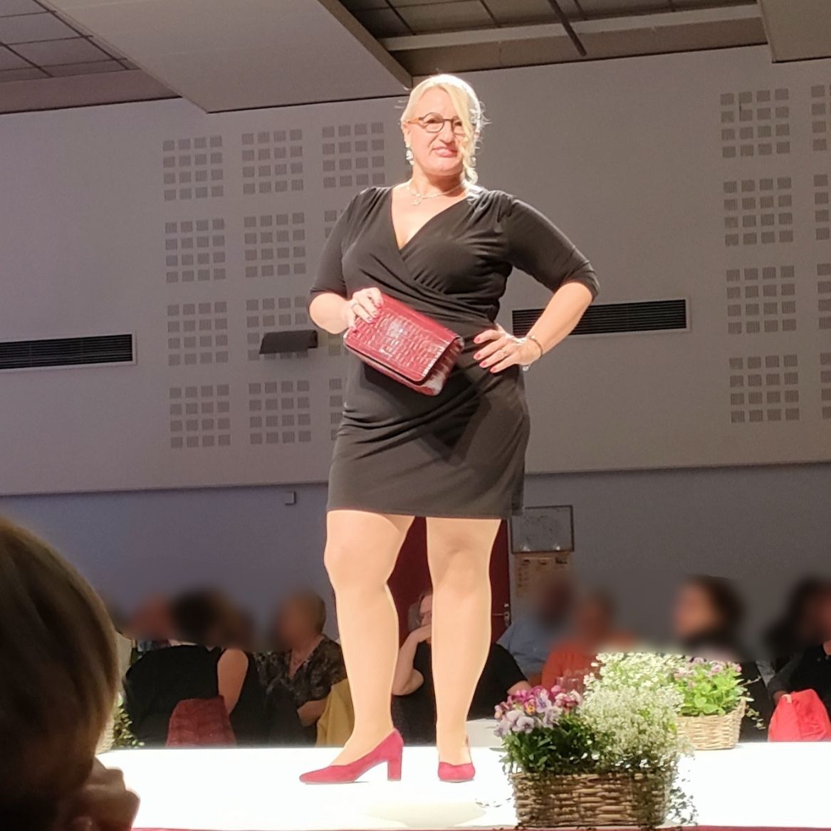 Femme qui défile avec un sac rouge
