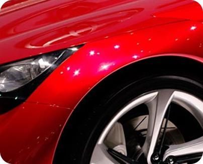 Un primer plano del guardabarros y la rueda de un coche rojo.