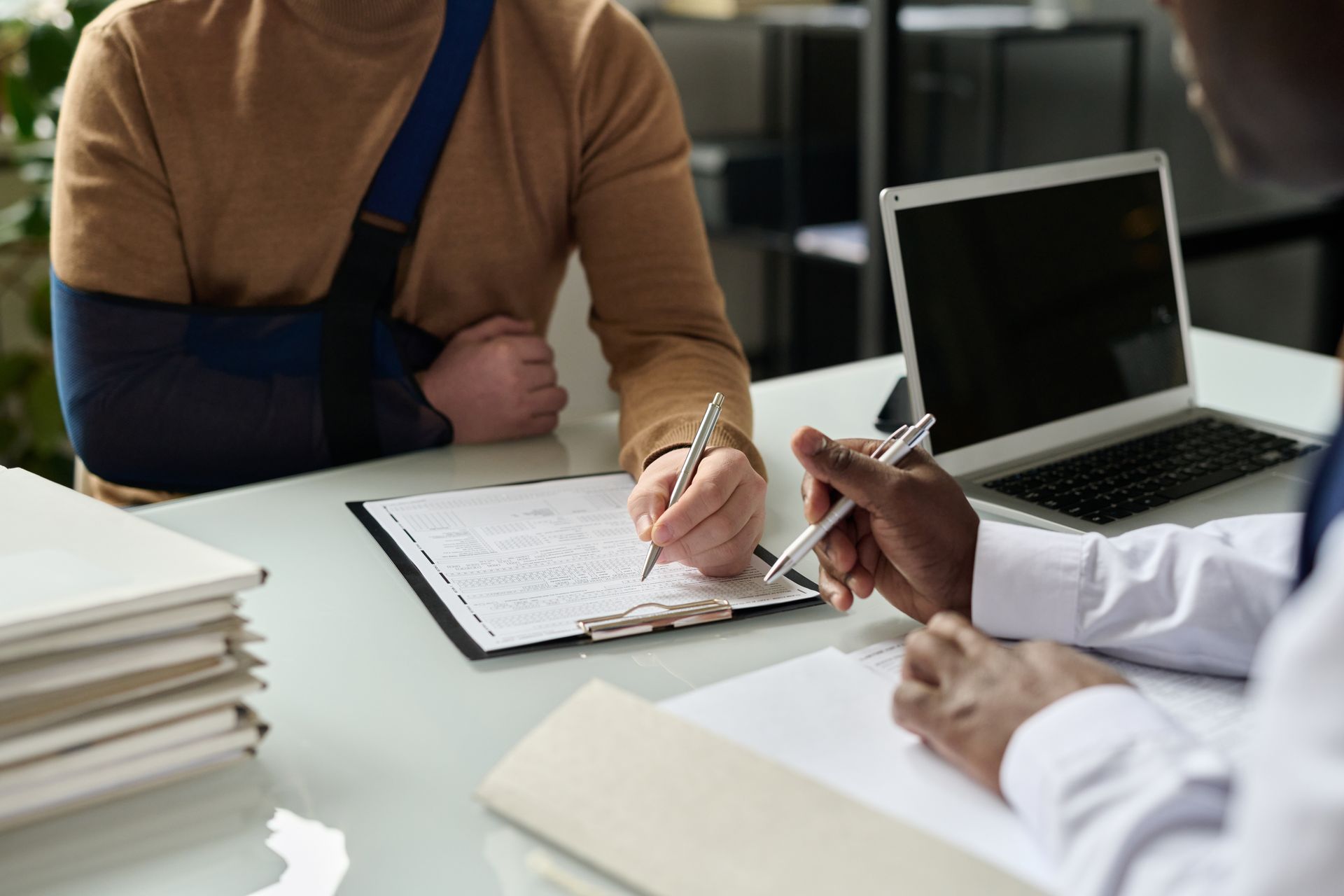 Client avec un bras en écharpe dans un bureau