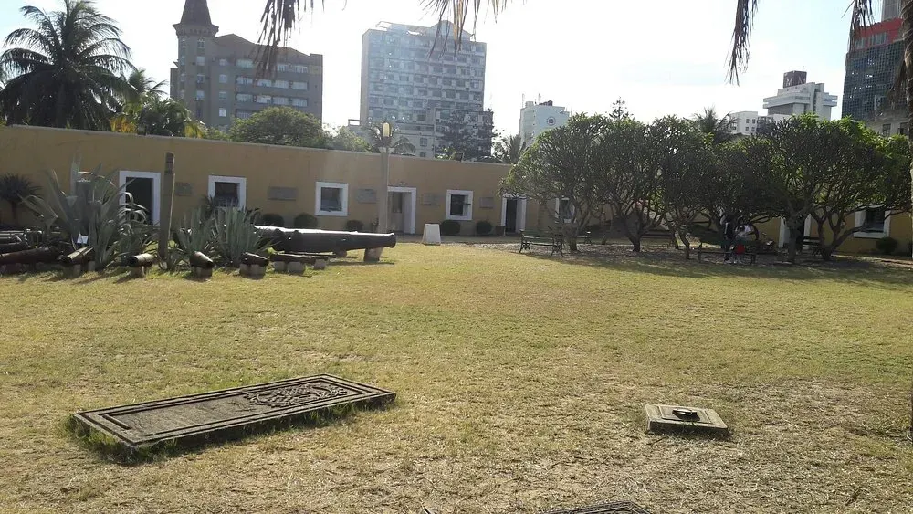 Um grande campo gramado com um prédio ao fundo