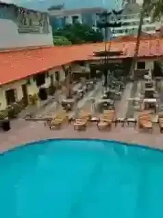 An aerial view of a large swimming pool surrounded by chairs and tables.