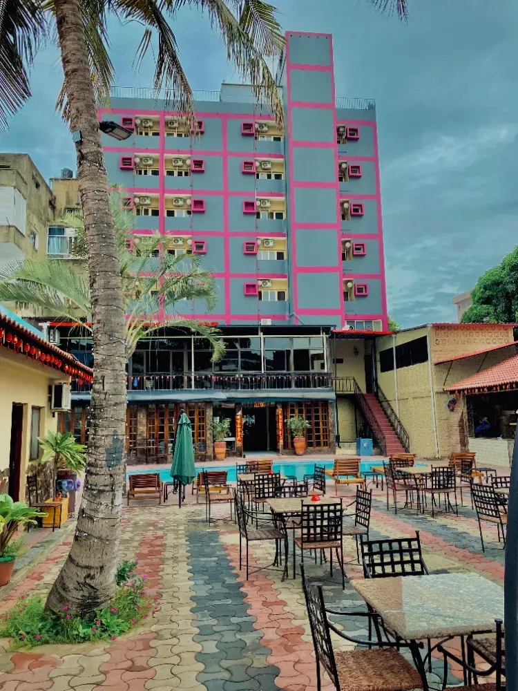 A large building with tables and chairs in front of it.