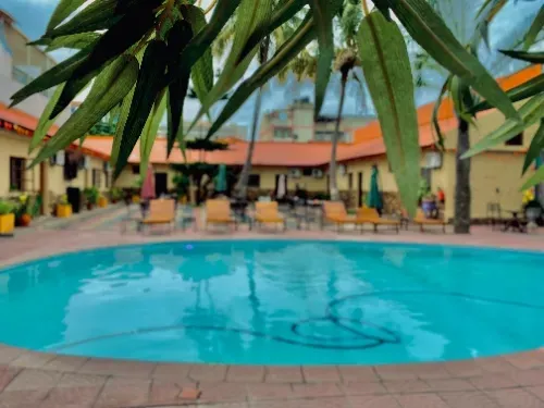 Uma grande piscina rodeada de cadeiras e palmeiras