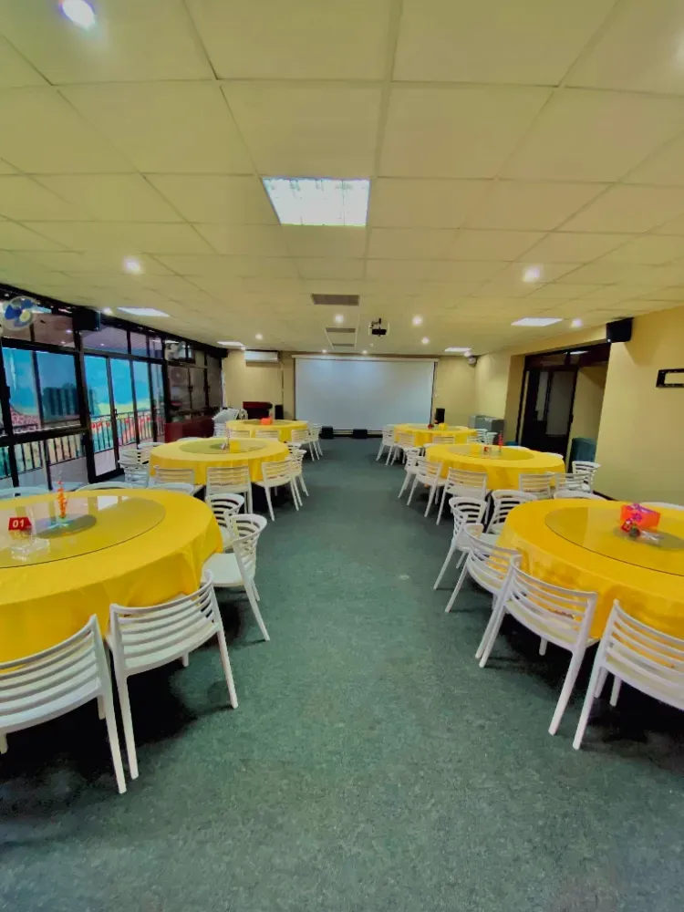 A large room with tables and chairs set up for a party.
