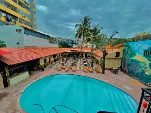 Uma vista aérea de uma grande piscina cercada por edifícios e palmeiras.