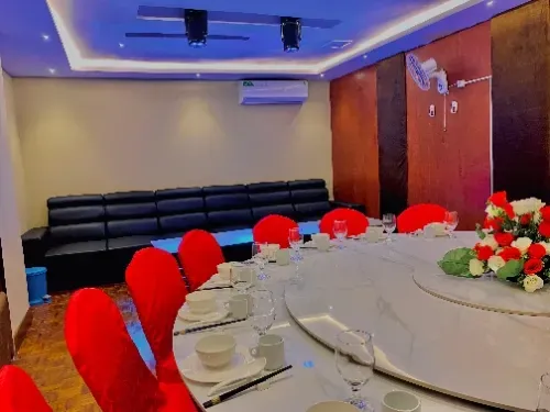 Uma sala de jantar com uma mesa redonda e cadeiras vermelhas.