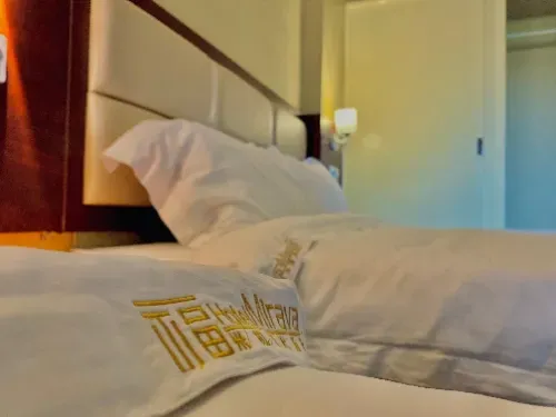 Um quarto de hotel com uma cama e um travesseiro que diz