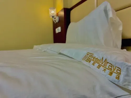 Uma cama com uma toalha que diz maya nela