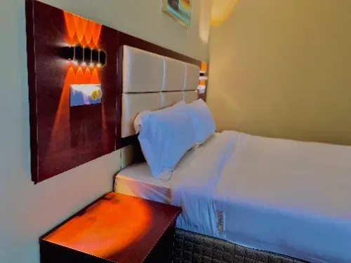 Um quarto de hotel com uma cama e uma mesa de cabeceira