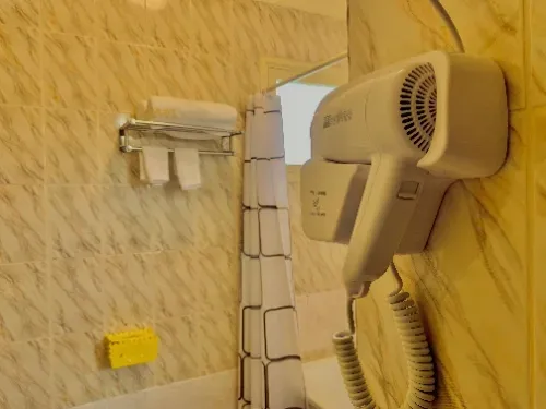 Um banheiro com um secador de cabelo pendurado na parede.