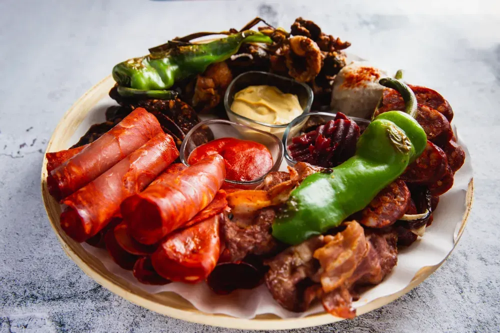 A plate of meat and vegetables on a table.