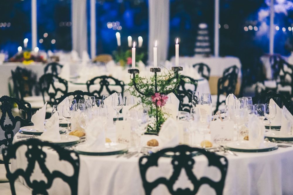 Uma mesa posta para uma recepção de casamento com velas sobre ela.