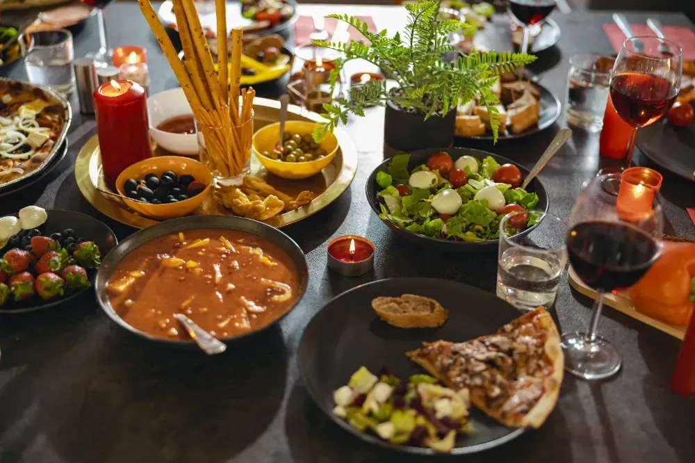 A table topped with plates of food and wine glasses.