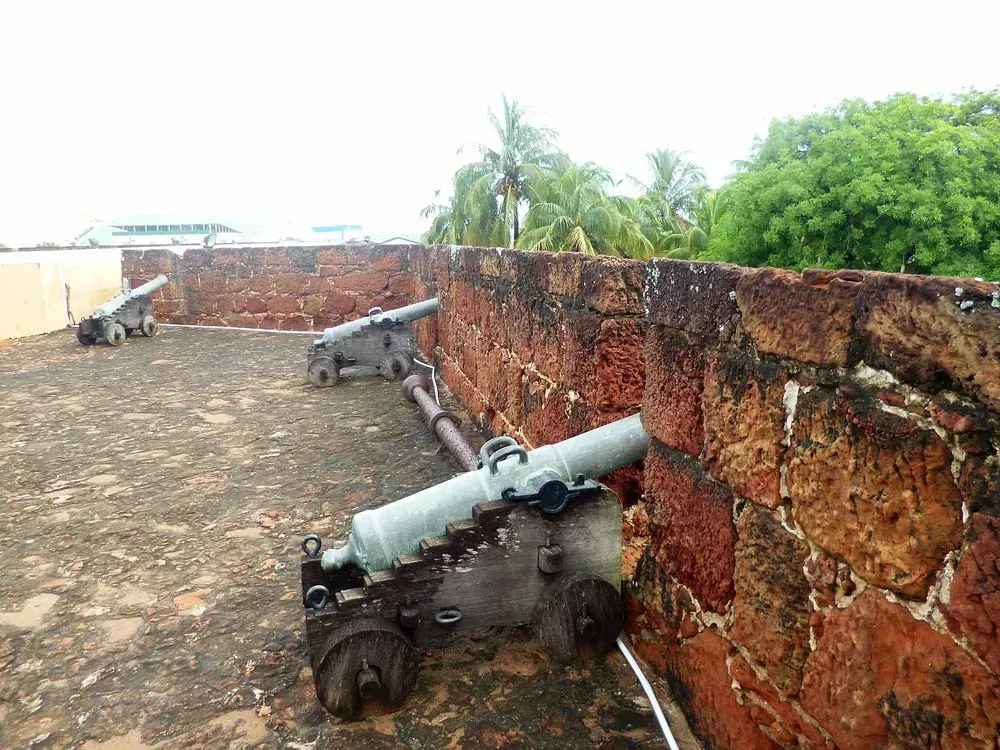 A group of cannons sitting on top of a brick wall.