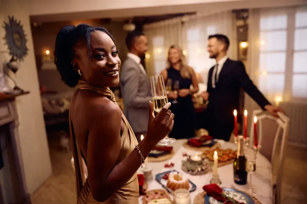 Uma mulher está segurando uma taça de champanhe em um jantar.