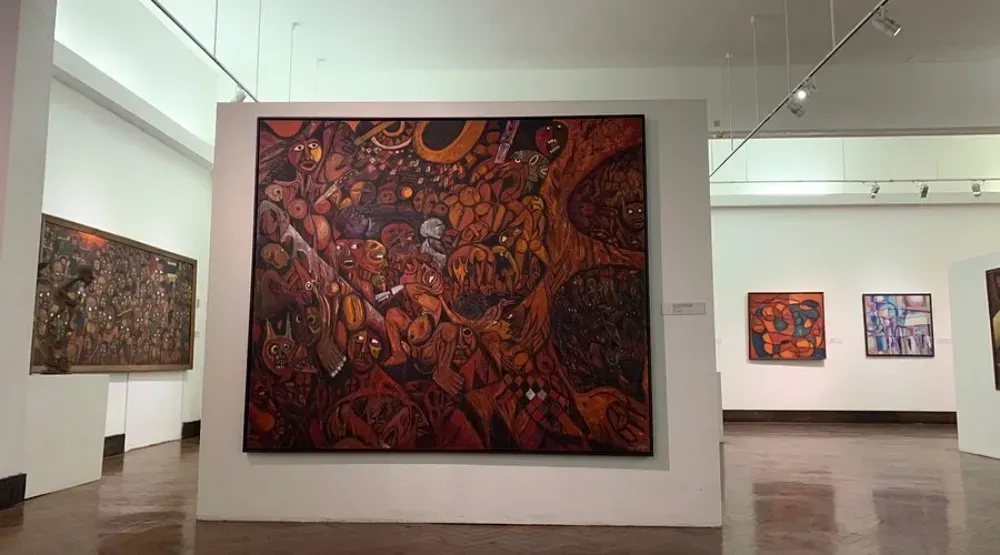 Uma grande pintura está pendurada na parede de um museu.