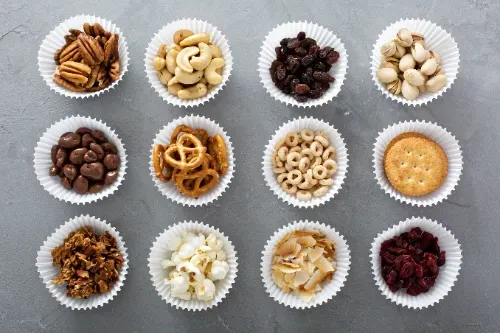 There are many different types of snacks in the bowls.