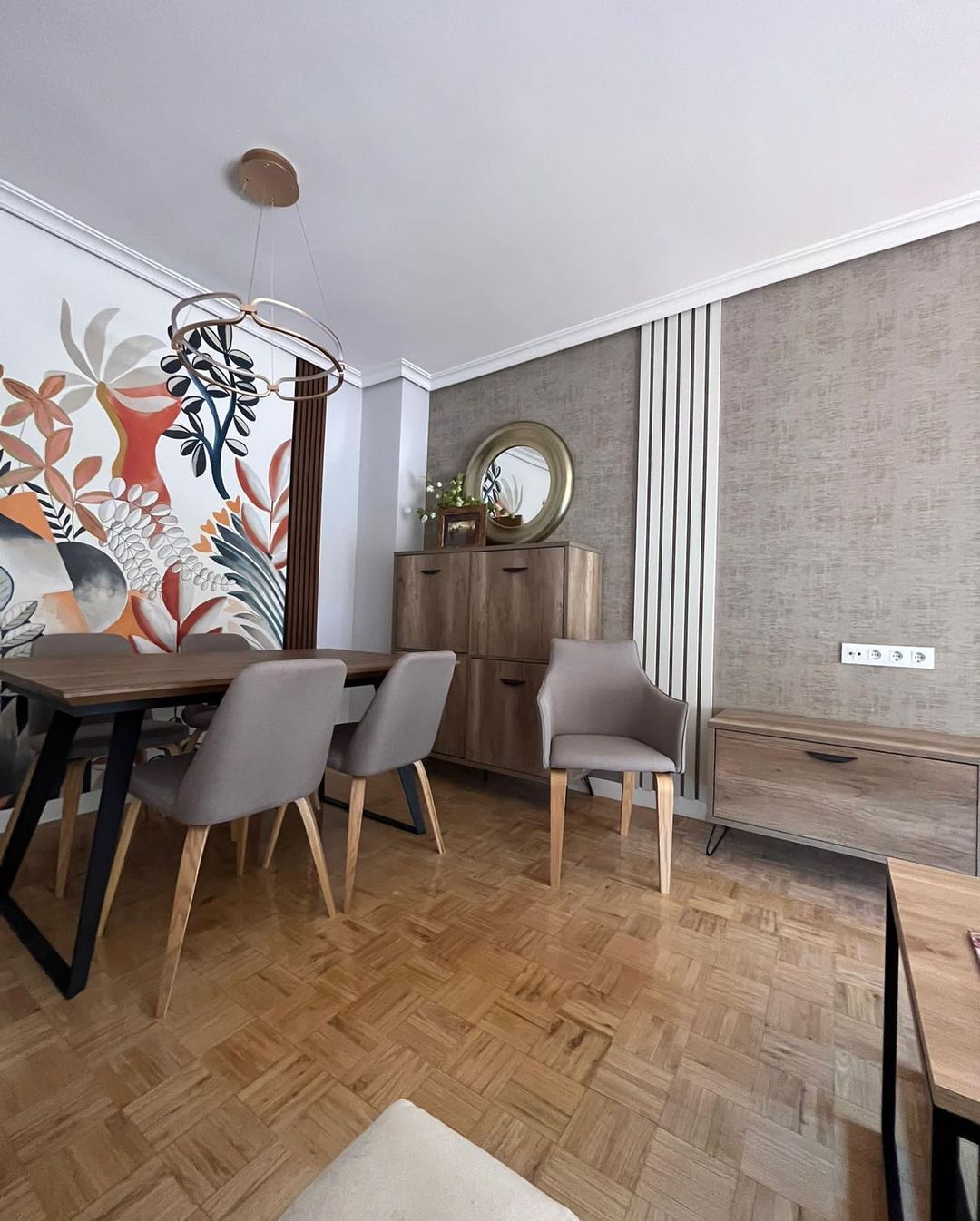 Una sala de estar con una mesa y sillas y un cuadro en la pared.