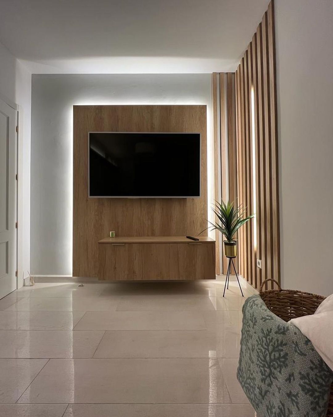 Una sala de estar con un televisor de pantalla plana montado en la pared.