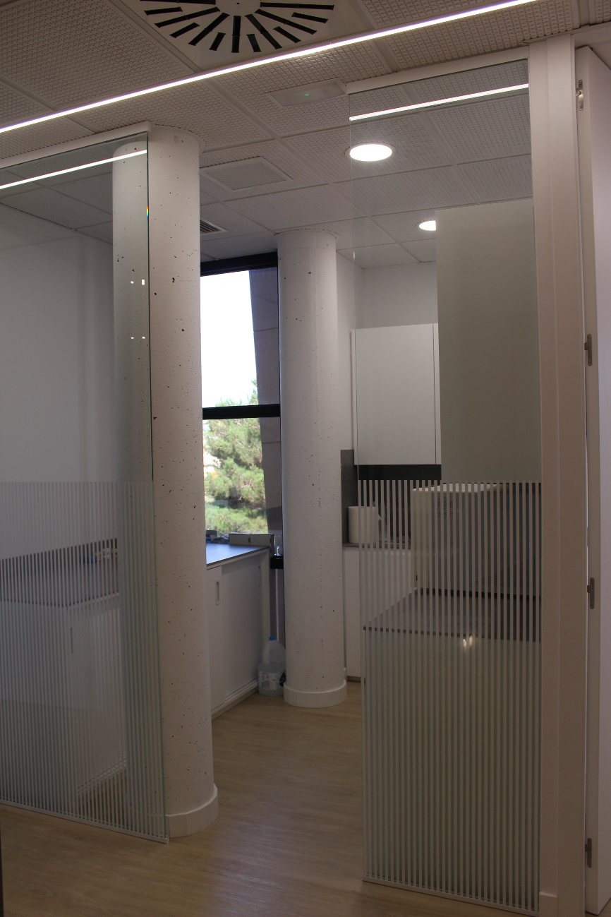 Una habitación con muchas ventanas y un ventilador de techo.