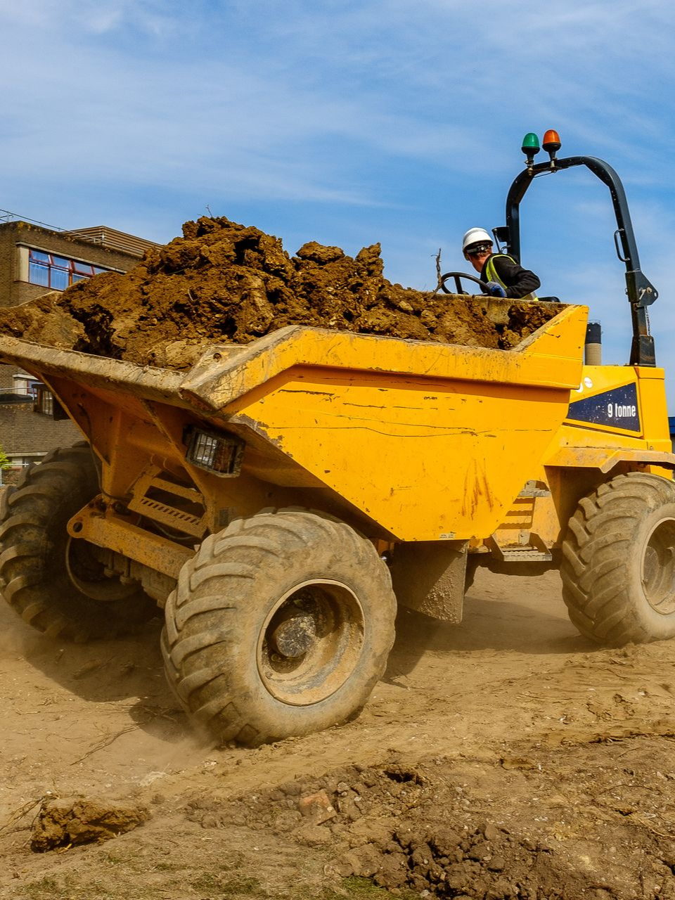 Camion-benne jaune transportant de la terre sur un chantier de construction