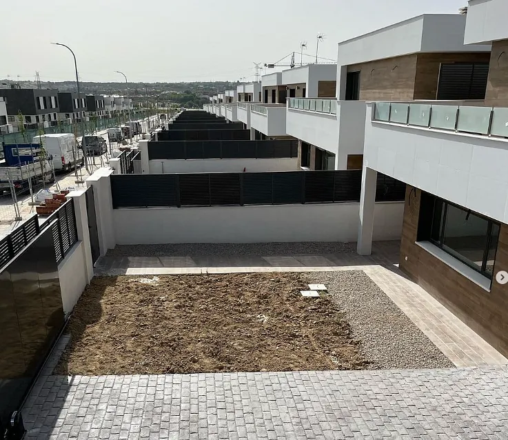 Una hilera de casas con un camino de entrada de ladrillos frente a ellas.