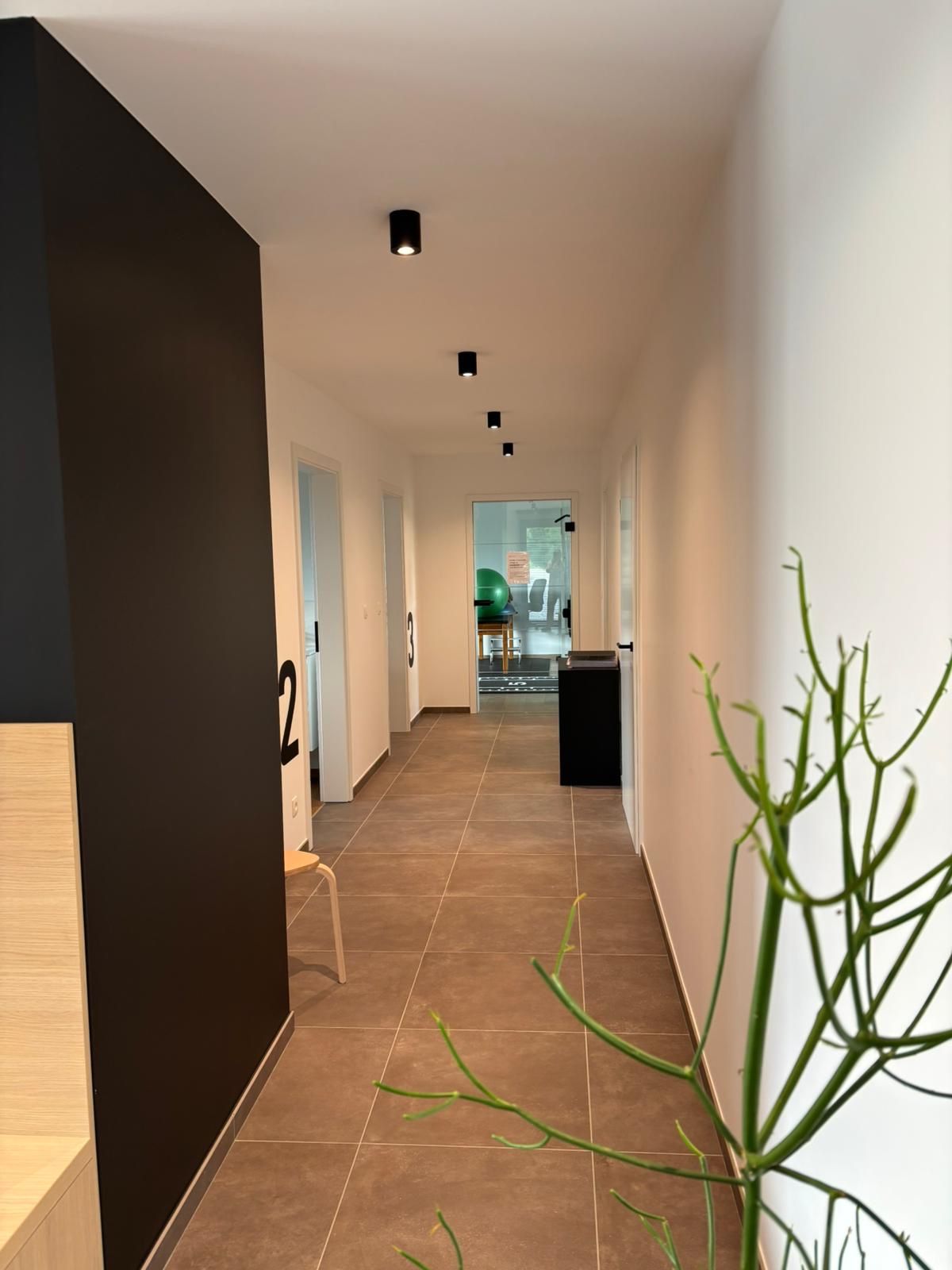 Long couloir avec sol carrelé au sein du Cabinet Kiné Ostéo Sauvage.